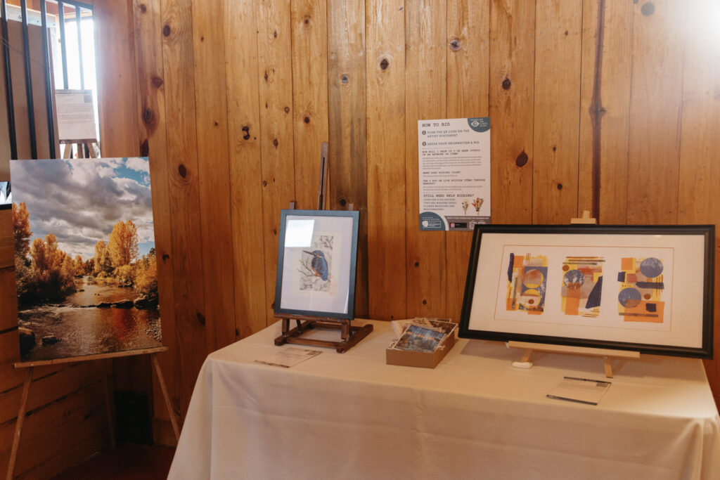 Artwork sits on a table in with a brown background.