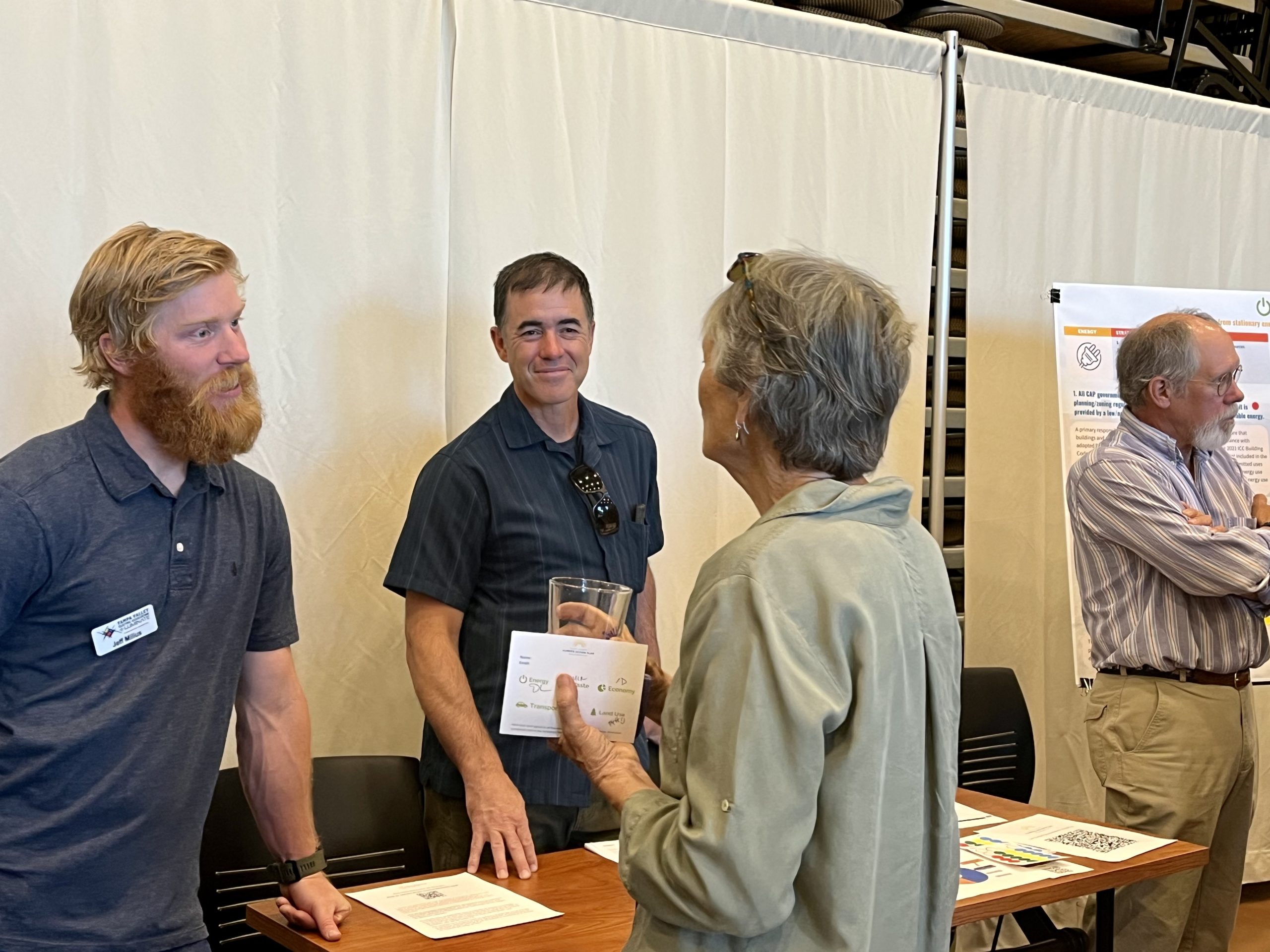 People standing at a table having a discussion.