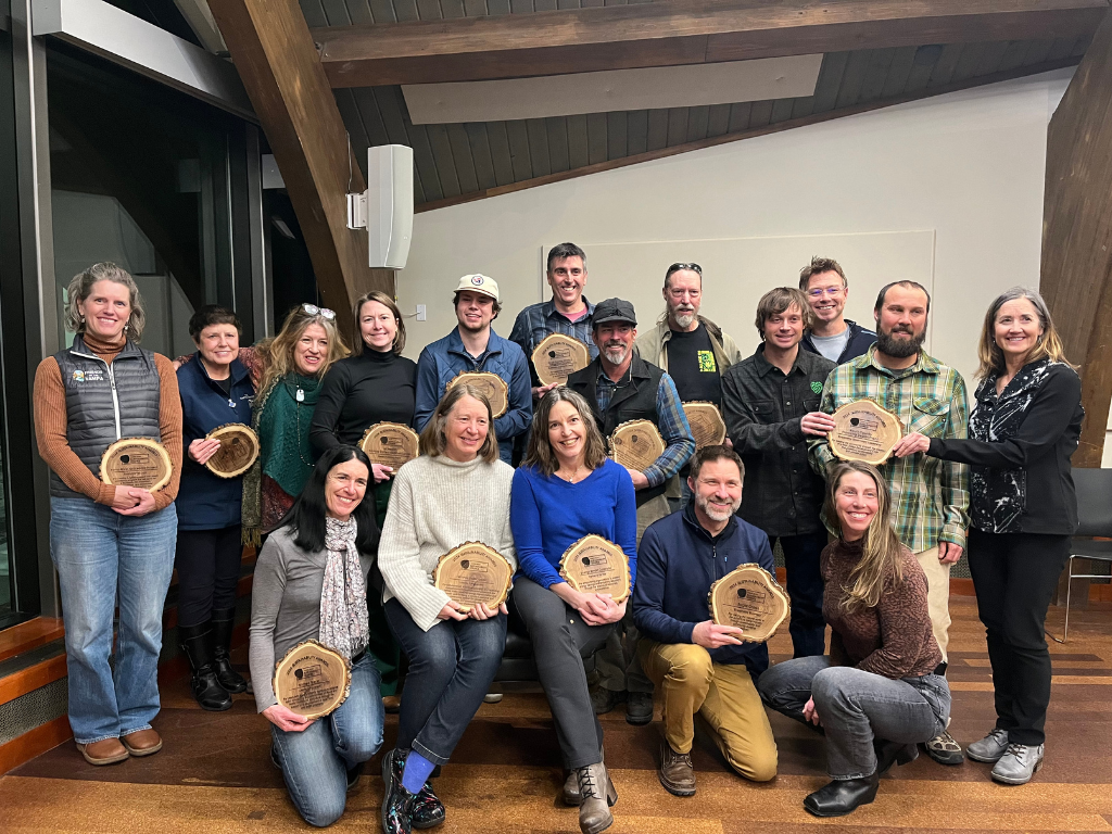 A group of people smile and pose with their Sustainability Awards.